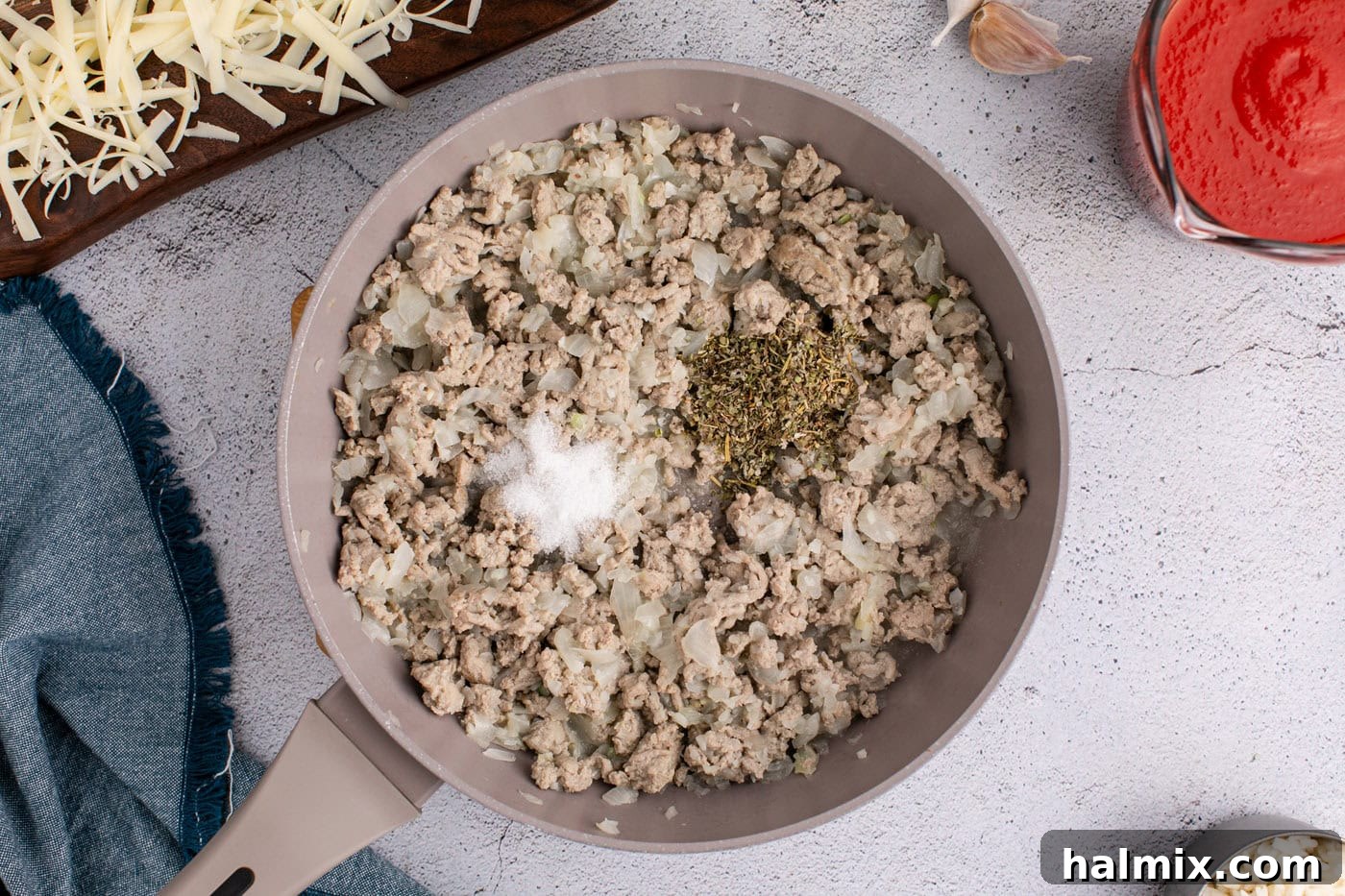 seasonings added to ground turkey mixture in a skillet