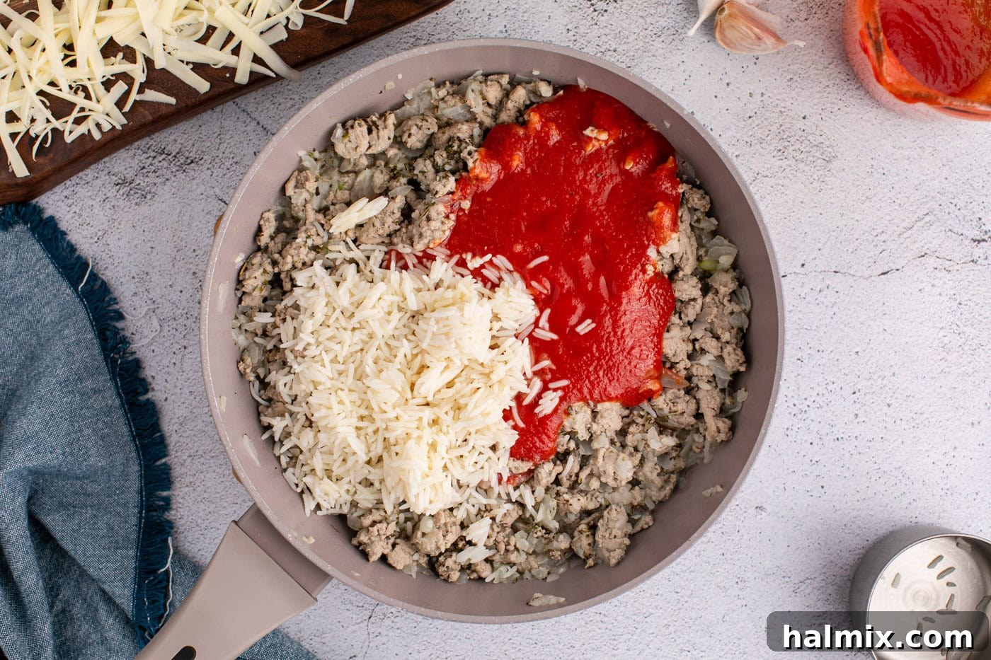 strained tomatoes and rice added to ground turkey mixture in a skillet