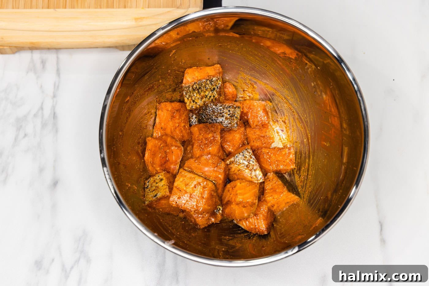 Golden Air Fryer Salmon Bites 8 salmon bites tossed in a wet rub in a mixing bowl