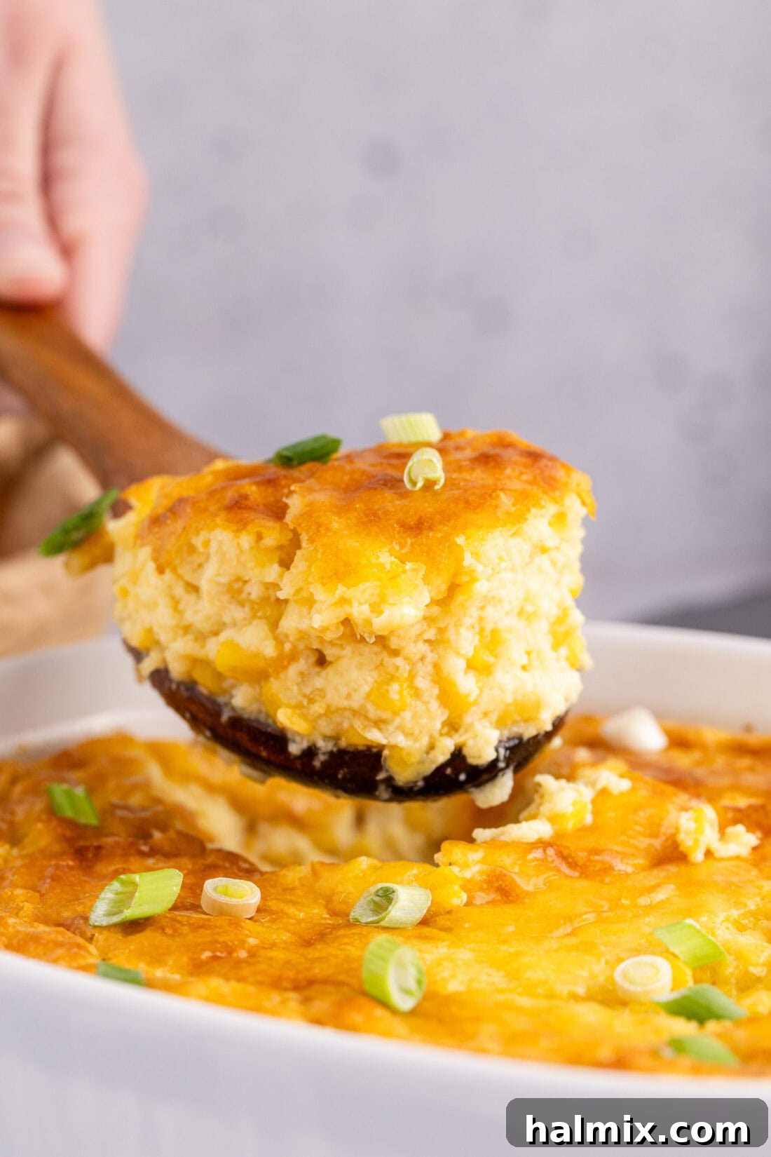 Scoop of Corn Pudding being lifted out of the baking dish