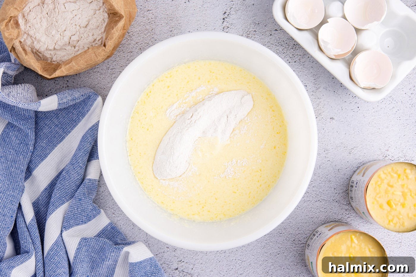 adding dry ingredients to wet ingredients in a mixing bowl
