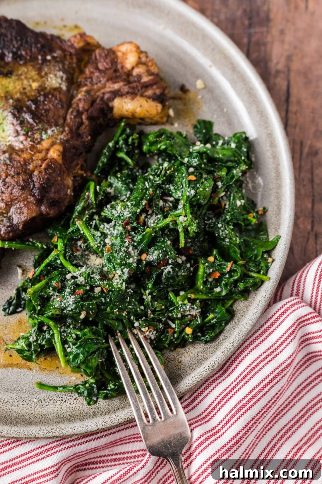 Air Fryer Spinach on a plate with a fork to the side, ready to be enjoyed.