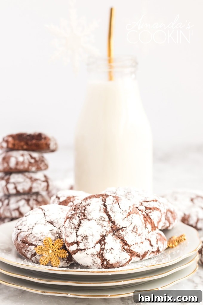 Chocolate Snow Cookies - perfect for holiday get-togethers or cookie exchanges! chocolate crinkle cookies on plate with bottle of milk