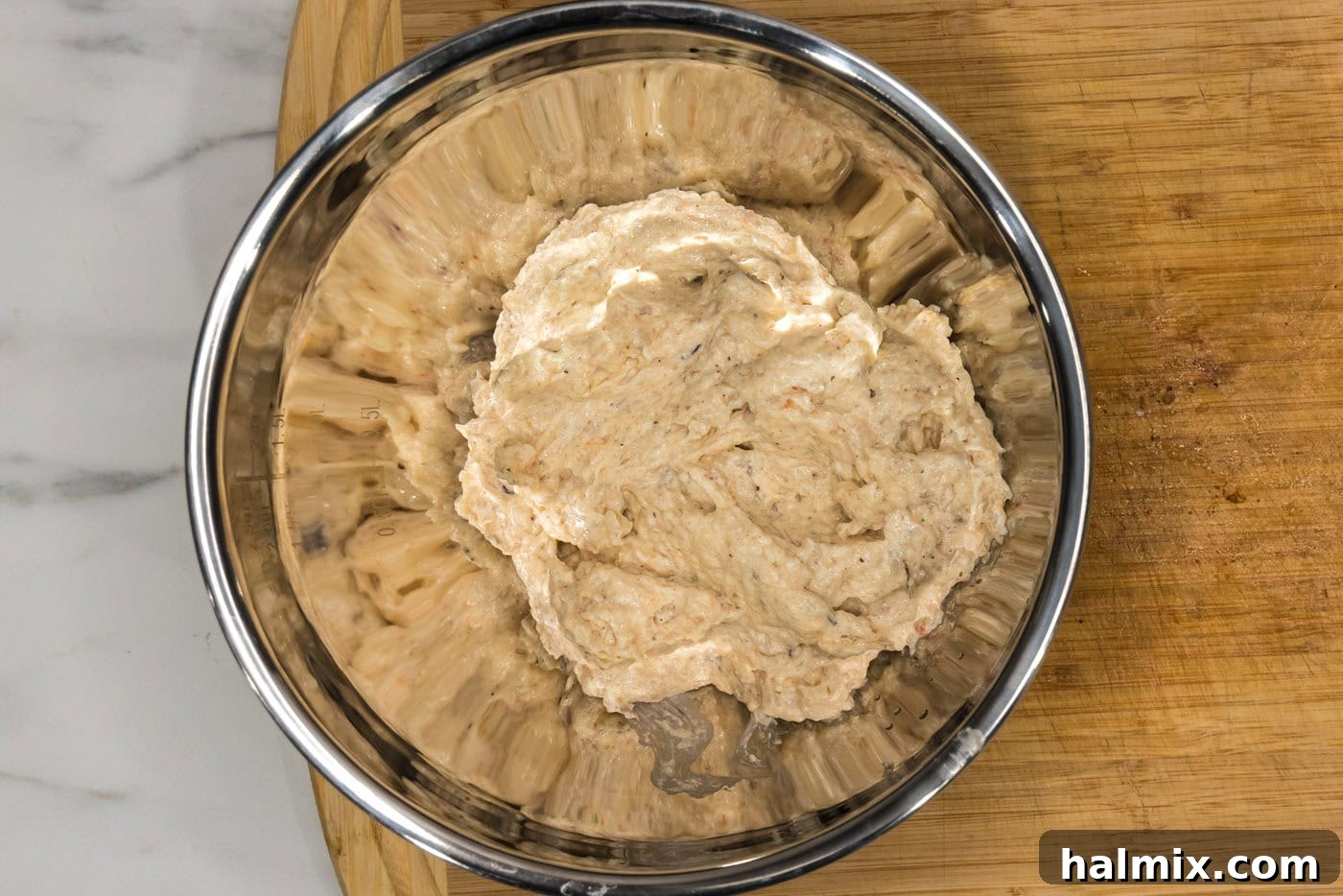 The blended shrimp mixture being added to the bowl containing the processed panko breadcrumbs.
