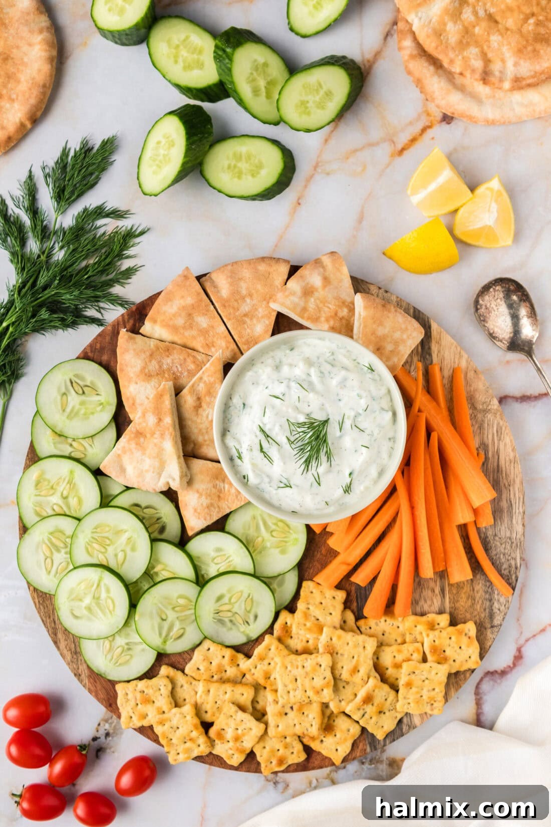 Freshly made Tzatziki Sauce in a rustic bowl, garnished with dill and olive oil, surrounded by crisp pita bread, cucumber slices, and carrot sticks on a wooden platter, inviting you to dip in.