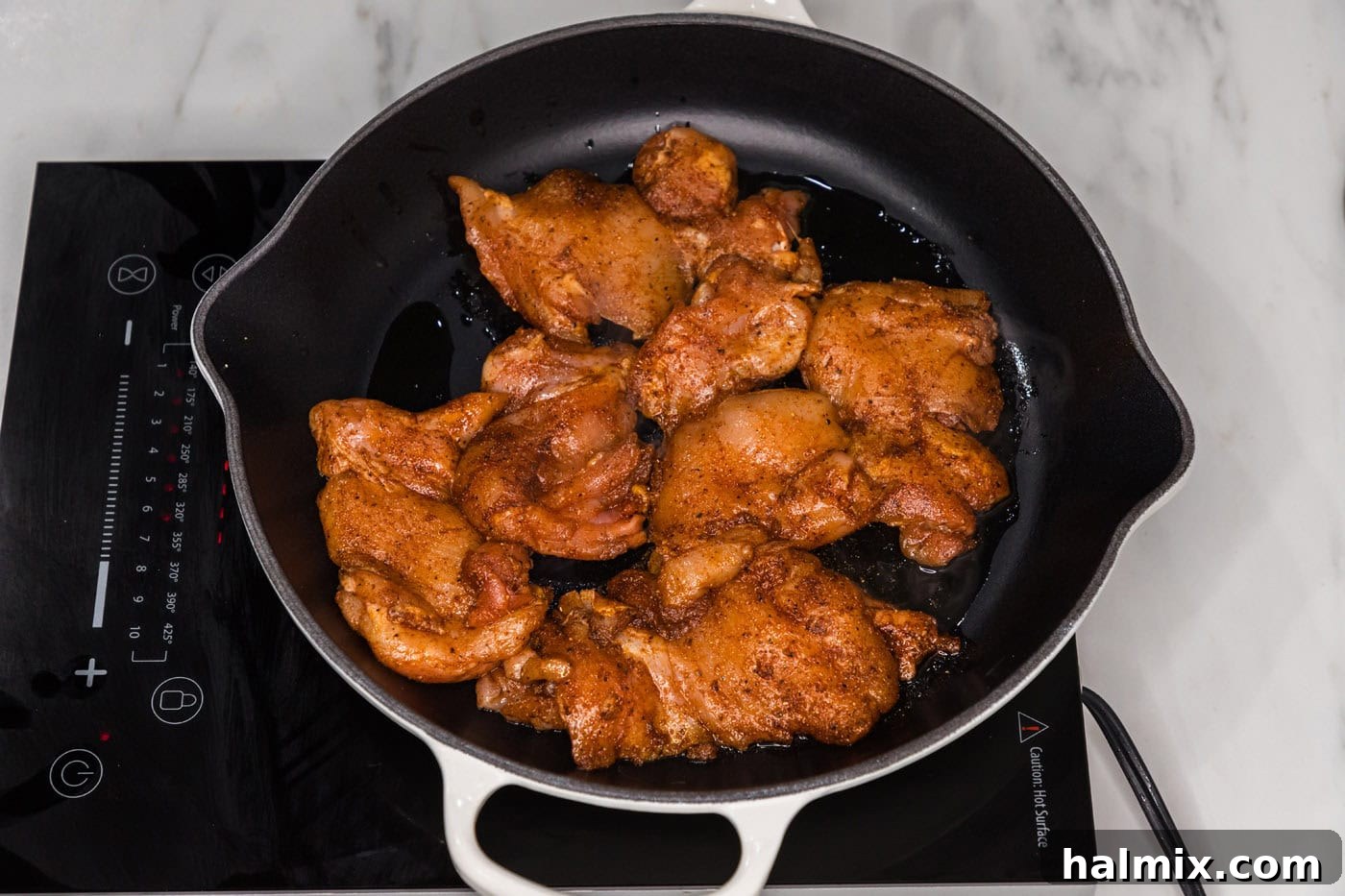 cooking marinated chicken in a pan