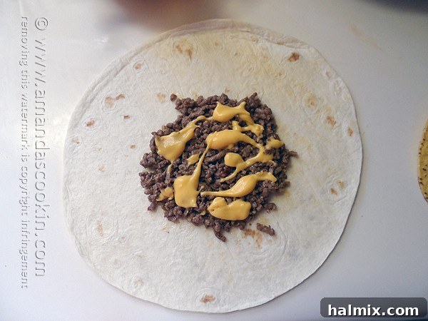 Warmed nacho cheese sauce being drizzled over a layer of seasoned ground beef on a flour tortilla, preparing for the next ingredient in the Crunchwrap Supreme.
