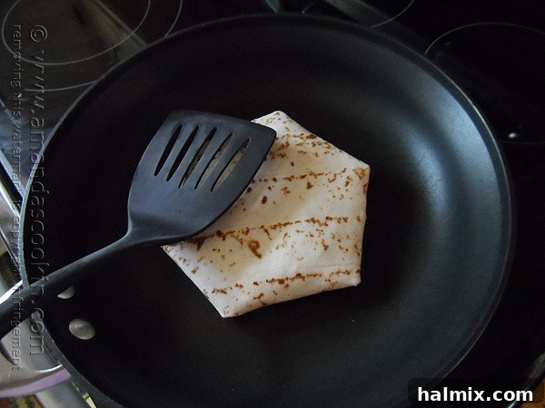 A fully folded homemade Crunchwrap Supreme placed face down in a hot skillet, ready to be grilled until golden brown and crispy.