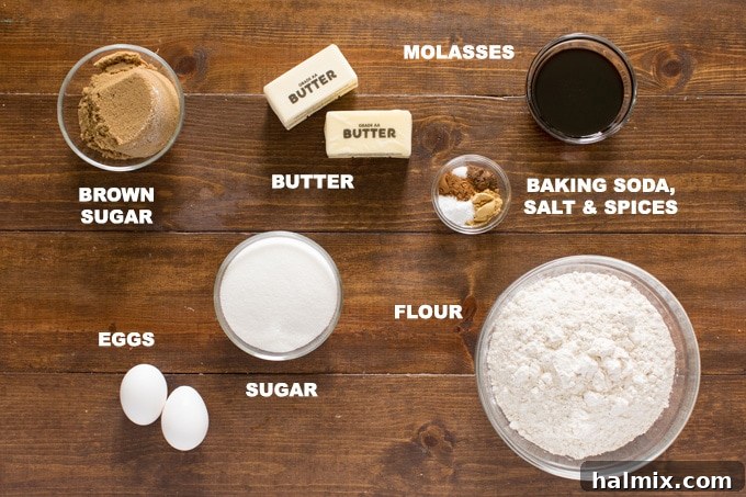 Various baking ingredients neatly laid out on a wooden surface, including flour, sugars, butter, eggs, molasses, and an array of spices, ready for making gingersnap cookies.