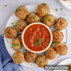 Close up photo of a plate of Chicken Meatballs with a bowl of marinara sauce