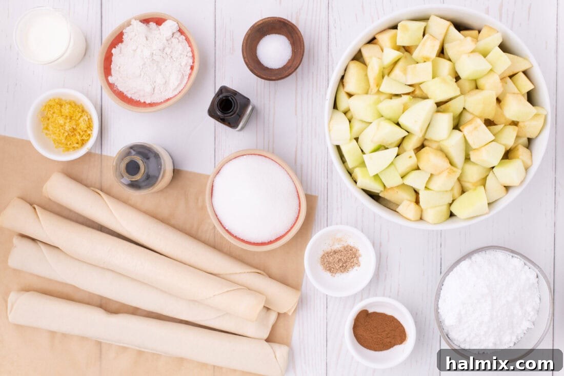 A collection of fresh ingredients laid out on a table, including sliced apples, bags of store-bought pie crusts, bowls of sugar and flour, and bottles of vanilla and almond extract, ready for making an Apple Slab Pie.