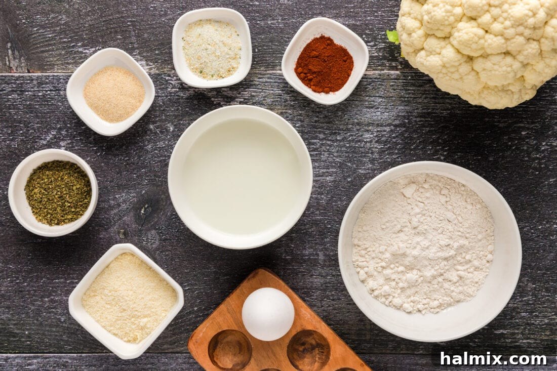Crispy Golden Cauliflower 4 A collection of fresh ingredients laid out, including cauliflower, eggs, milk, flour, and various spices, ready for making fried cauliflower