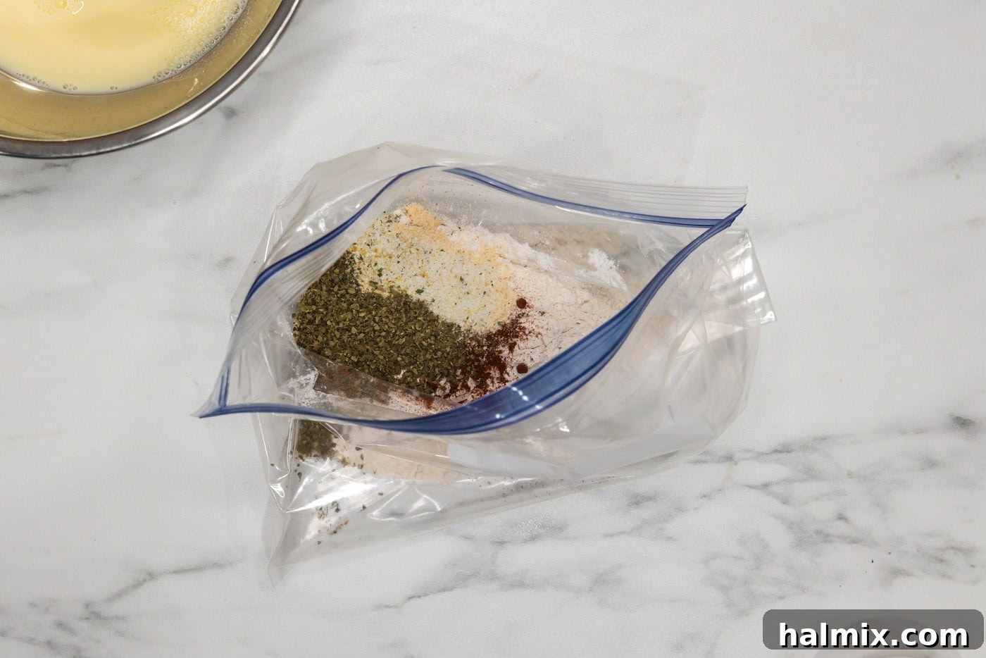 Crispy Golden Cauliflower 7 A gallon-sized zipper bag filled with flour and a blend of spices and Parmesan cheese, ready to be shaken