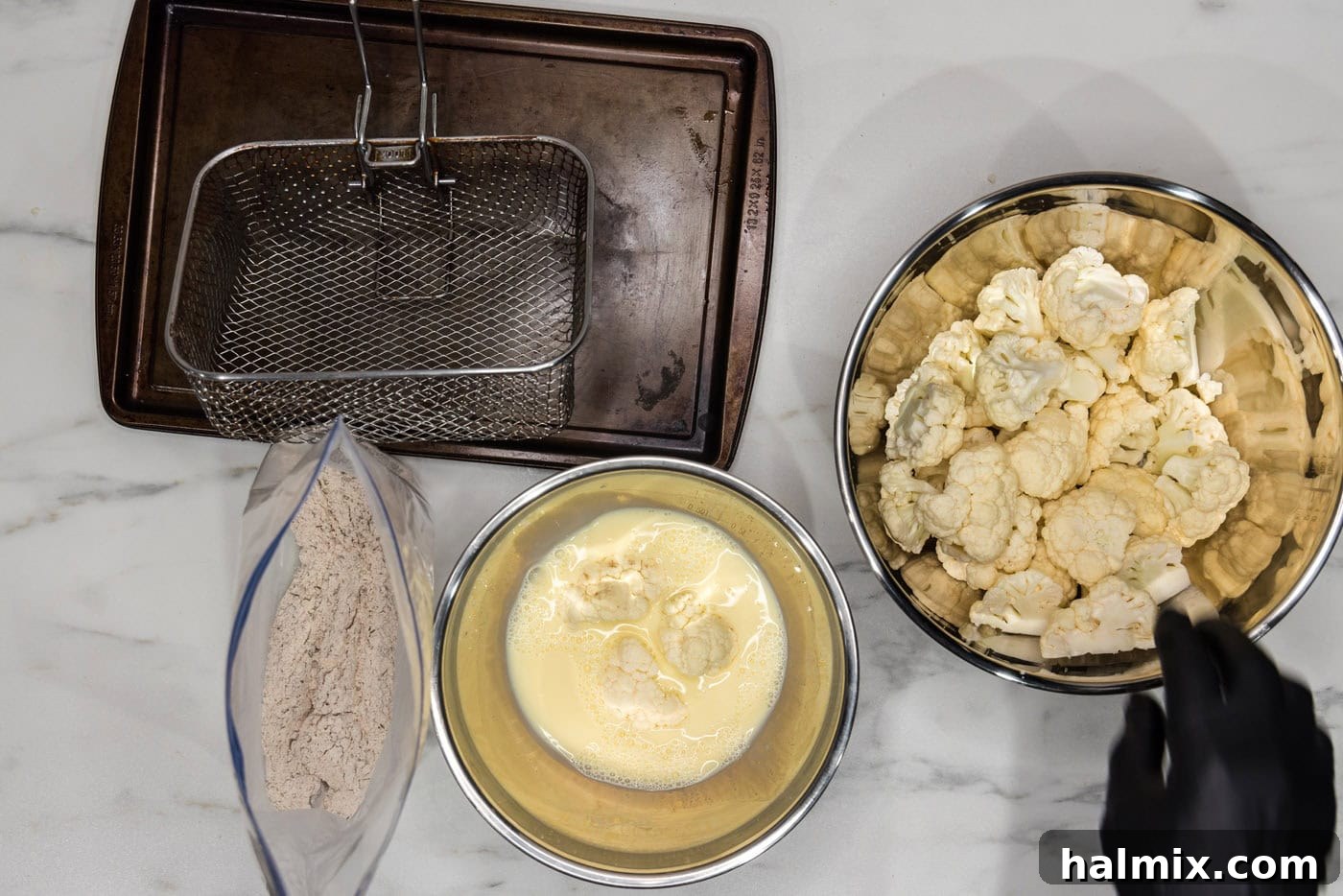 Crispy Golden Cauliflower 8 Cauliflower florets submerged in a bowl of whisked eggs and milk, getting coated