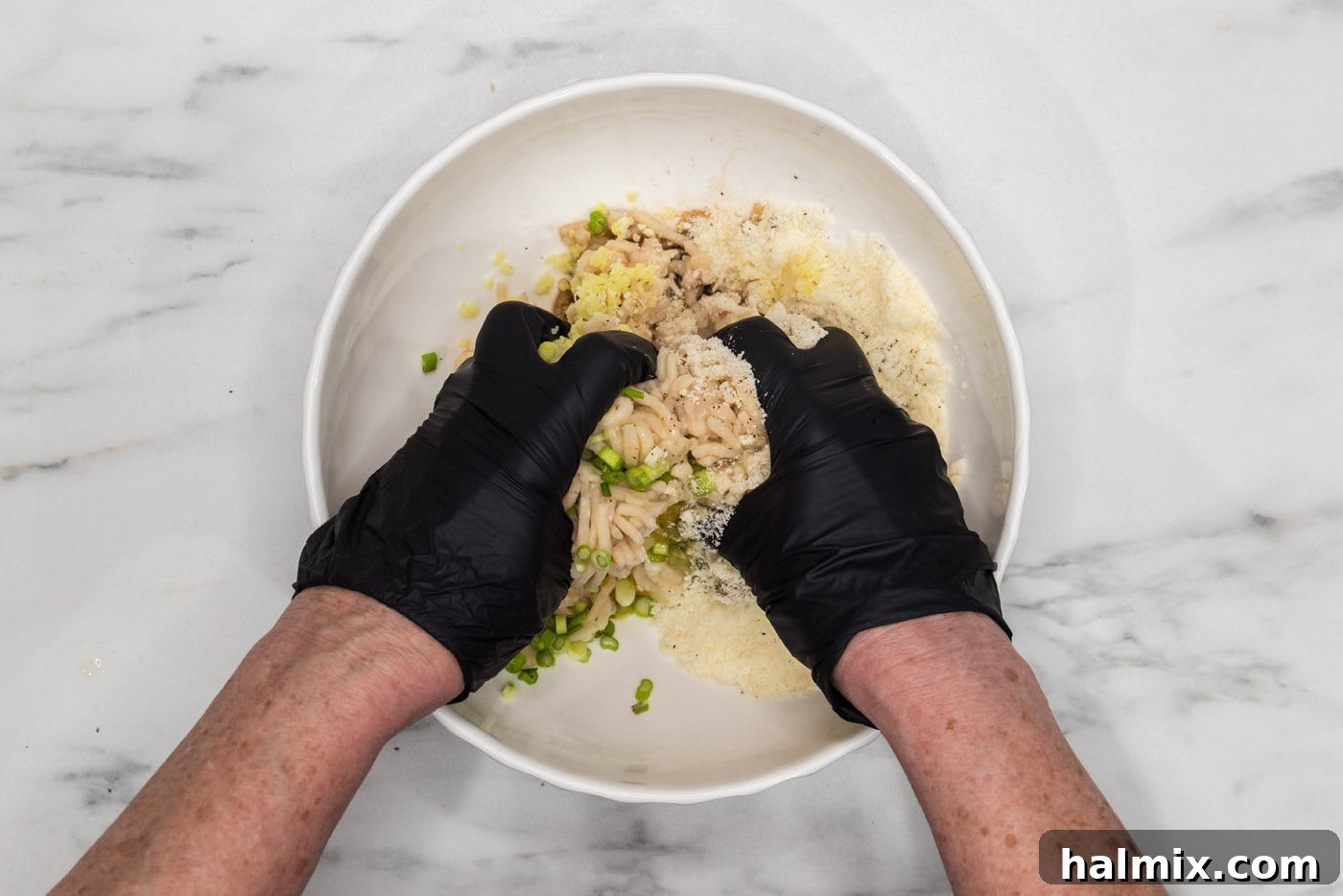 hands mixing ingredients for asian chicken meatballs