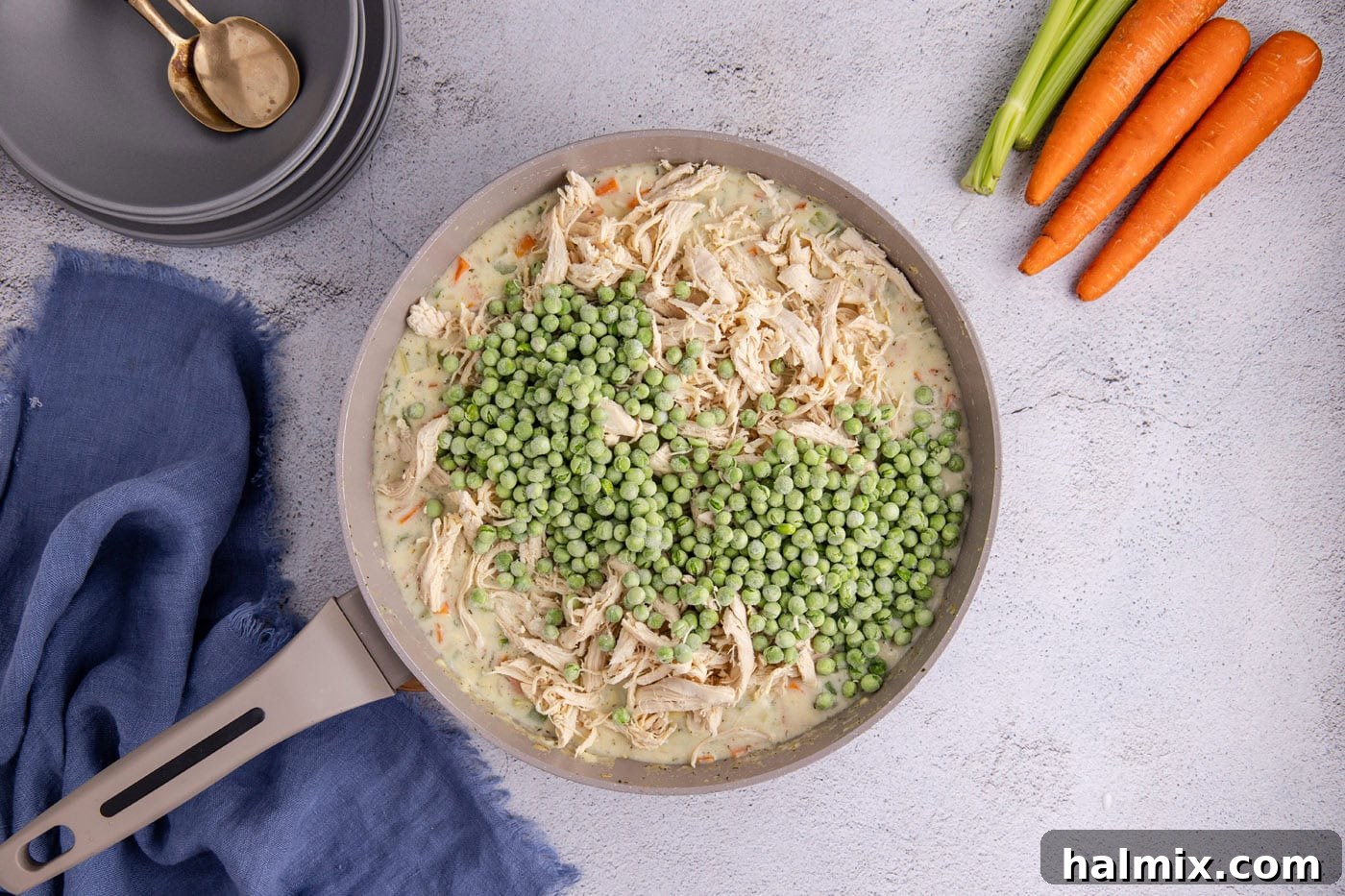 Easy Chicken Pot Pie Bake 9 frozen peas added to chicken pot pie mixture in a skillet