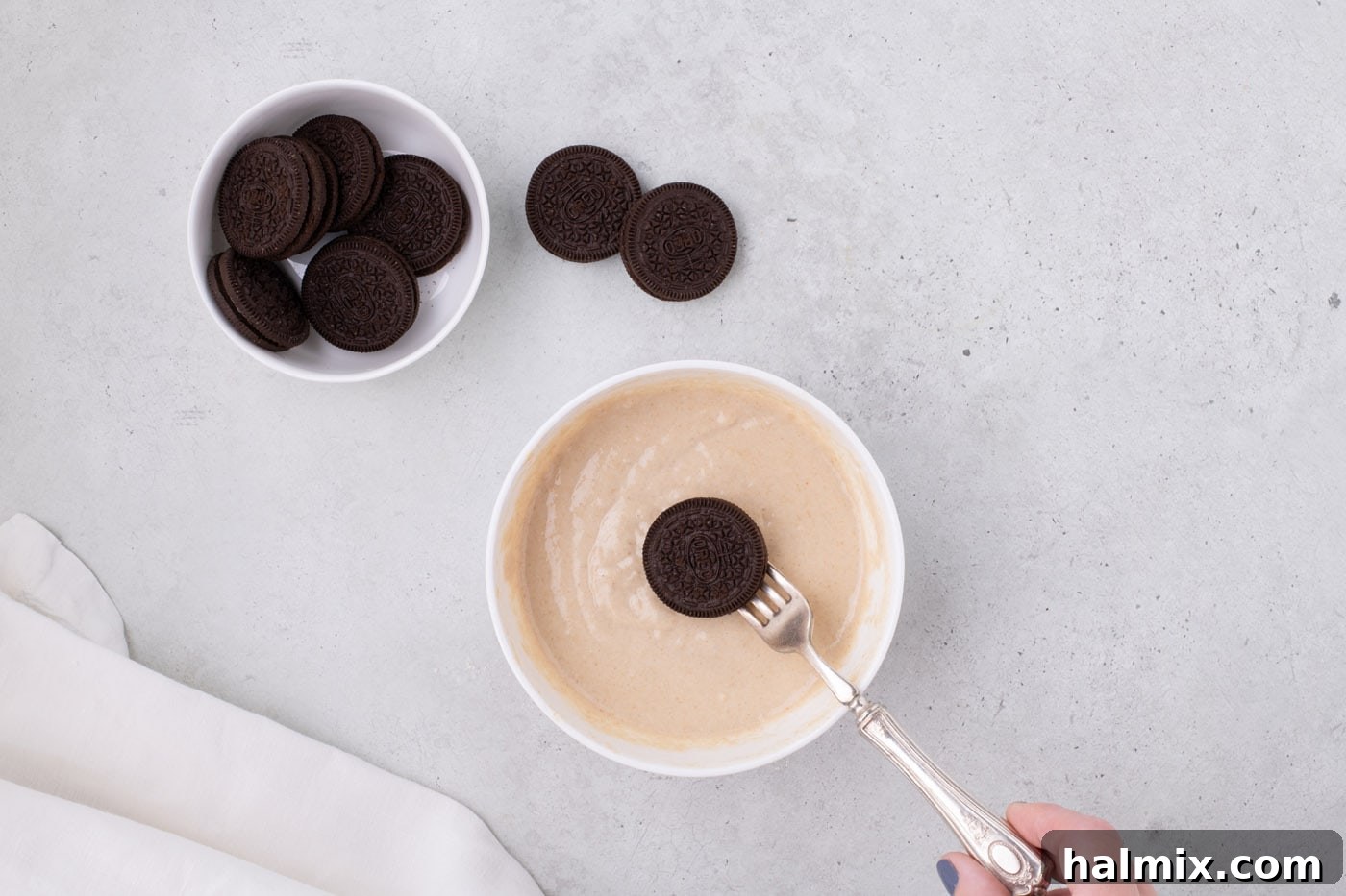 Air Fryer Oreo Magic 6 Dipping an Oreo into thick pancake batter with a fork, ready for the air fryer