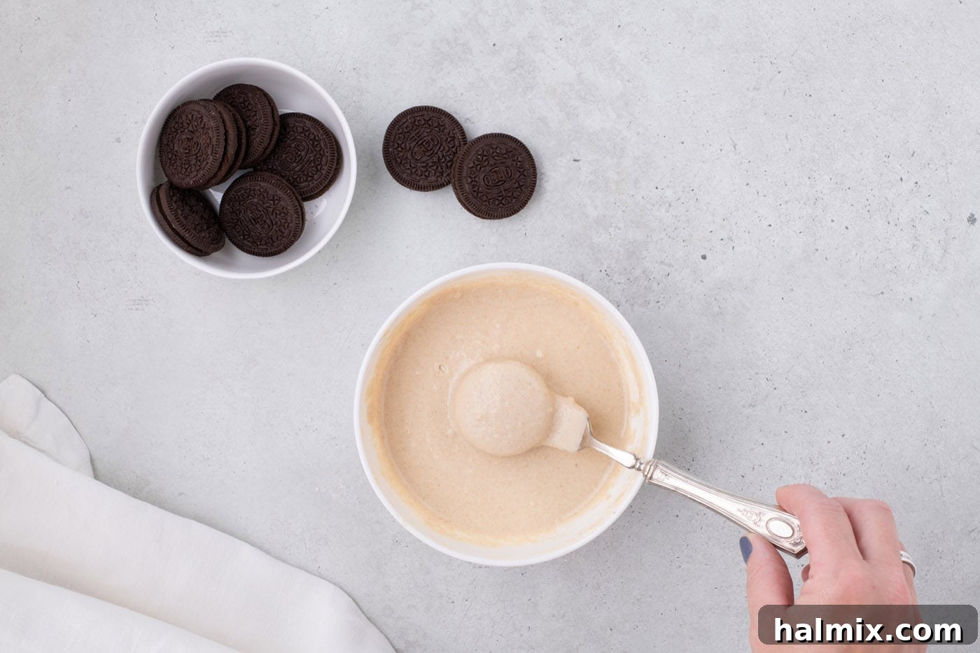 Air Fryer Oreo Magic 7 A batter-dipped Oreo resting on a fork, with excess batter tapped off