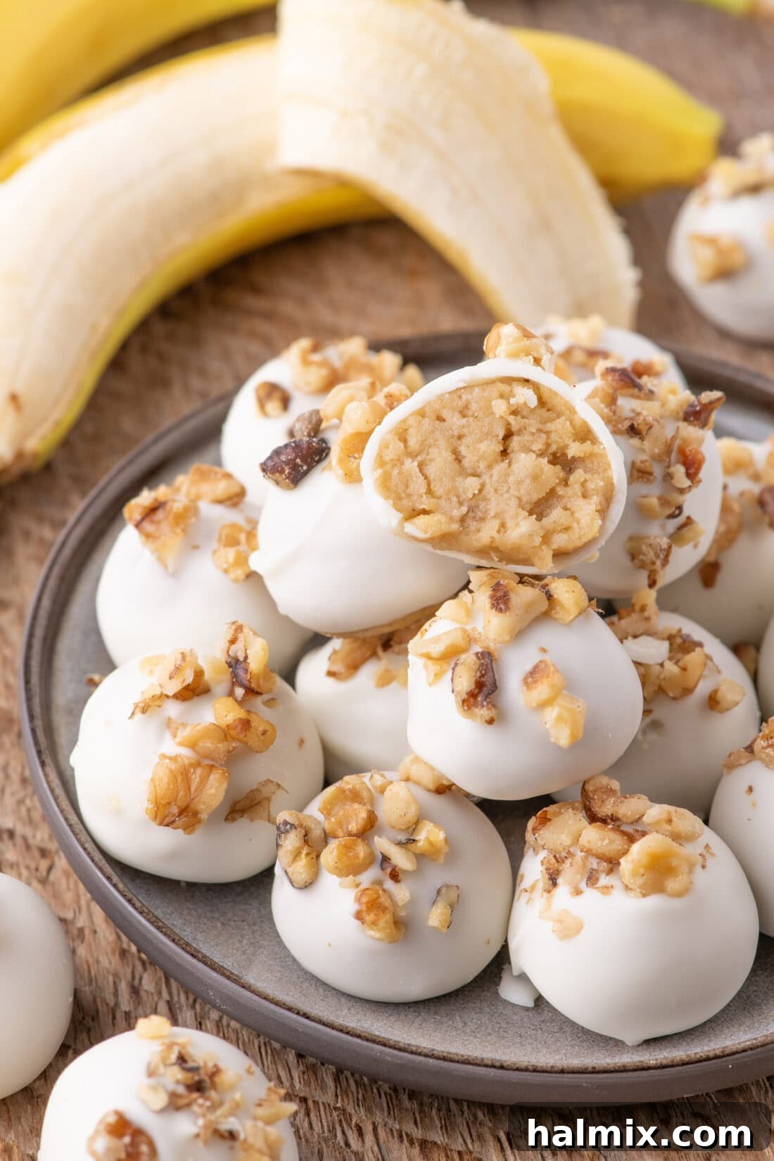 Banana Chocolate Bliss Bites 2 Banana Truffles stacked on a plate with one cut in half, showcasing creamy interior