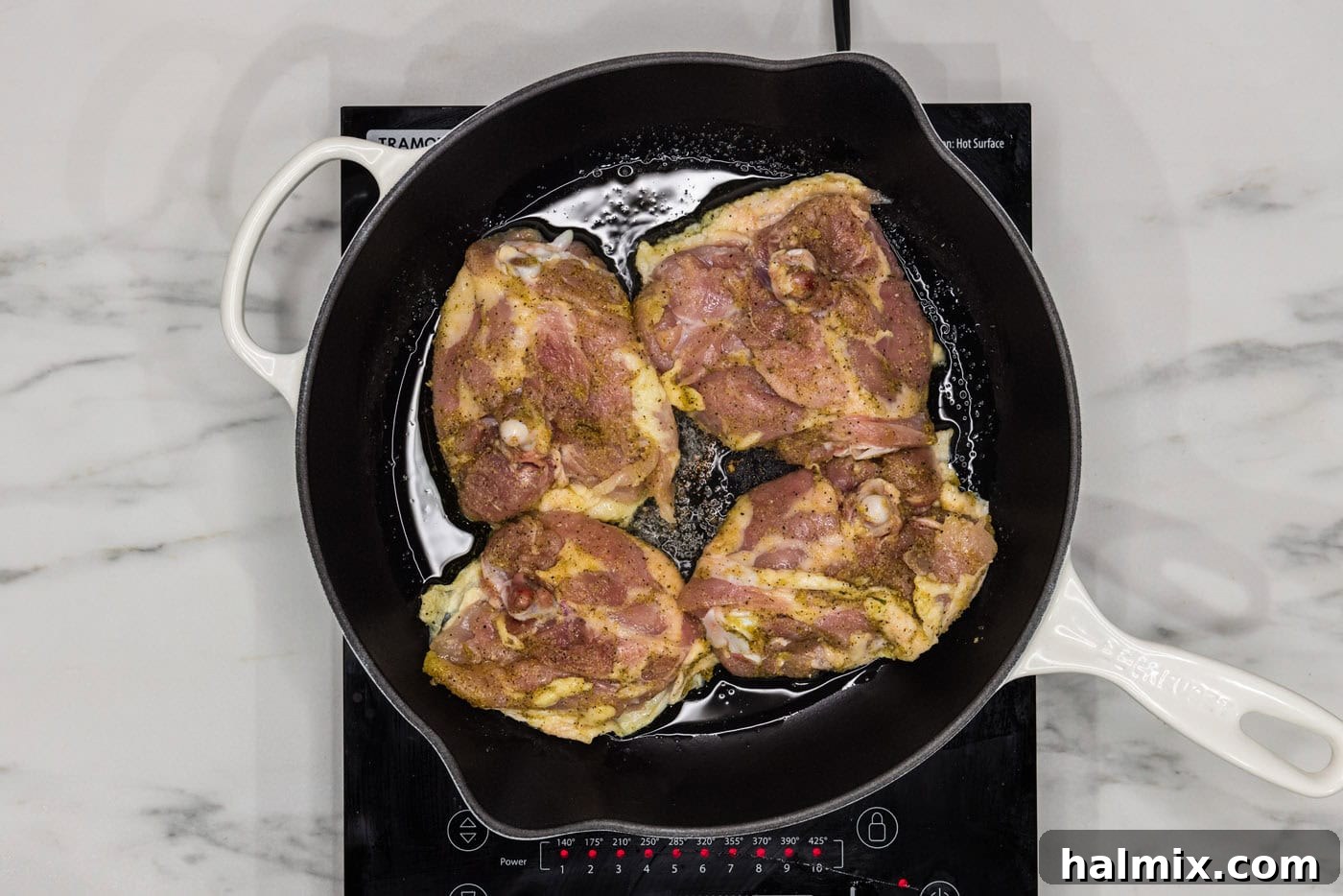pan searing chicken thighs in a skillet with oil