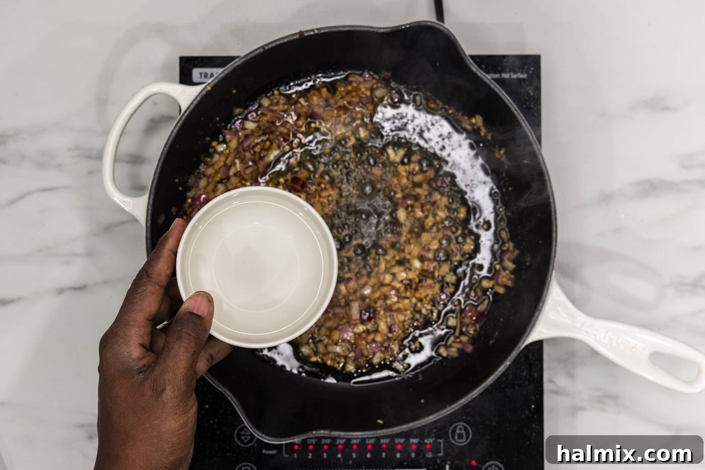 adding water to skillet with sauteed onion and garlic