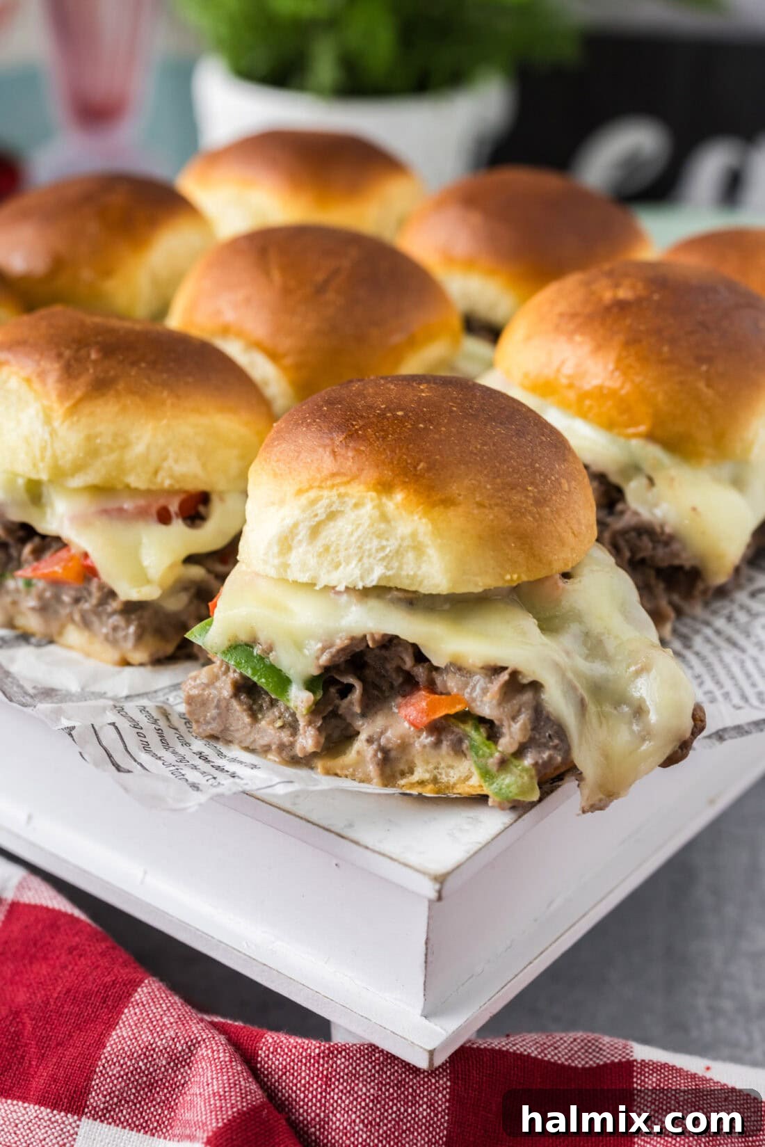 Philly Cheesesteak Slider Delights 3 Philly Cheesesteak Sliders on a white serving board