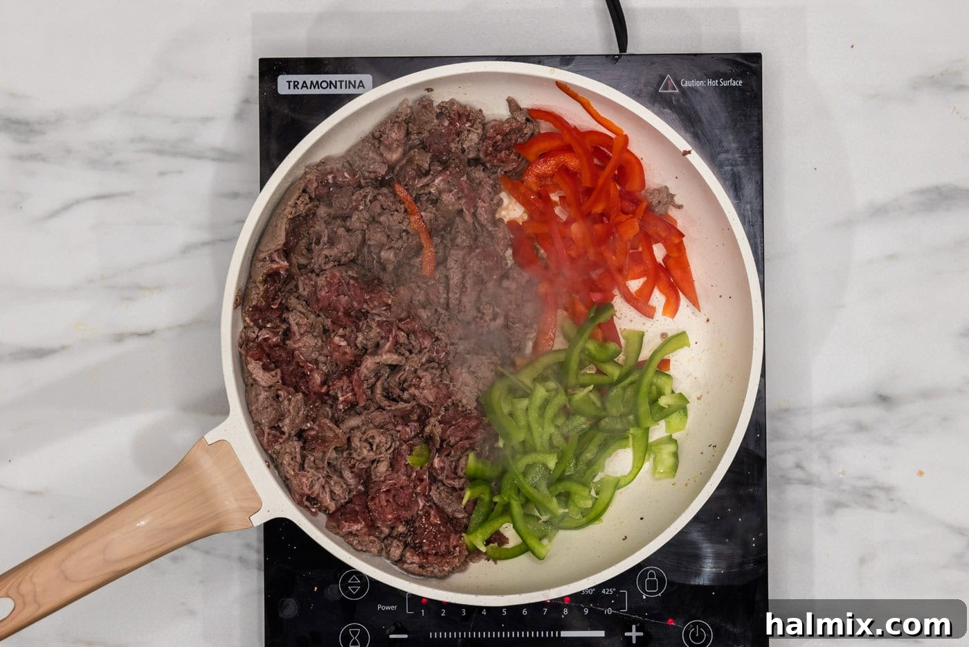 bell peppers in a skillet with shaved beef