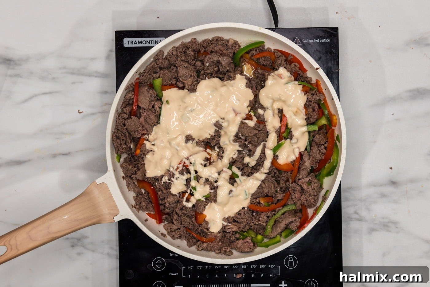 Philly Cheesesteak Slider Delights 7 queso blanco added to skillet with bell peppers and beef