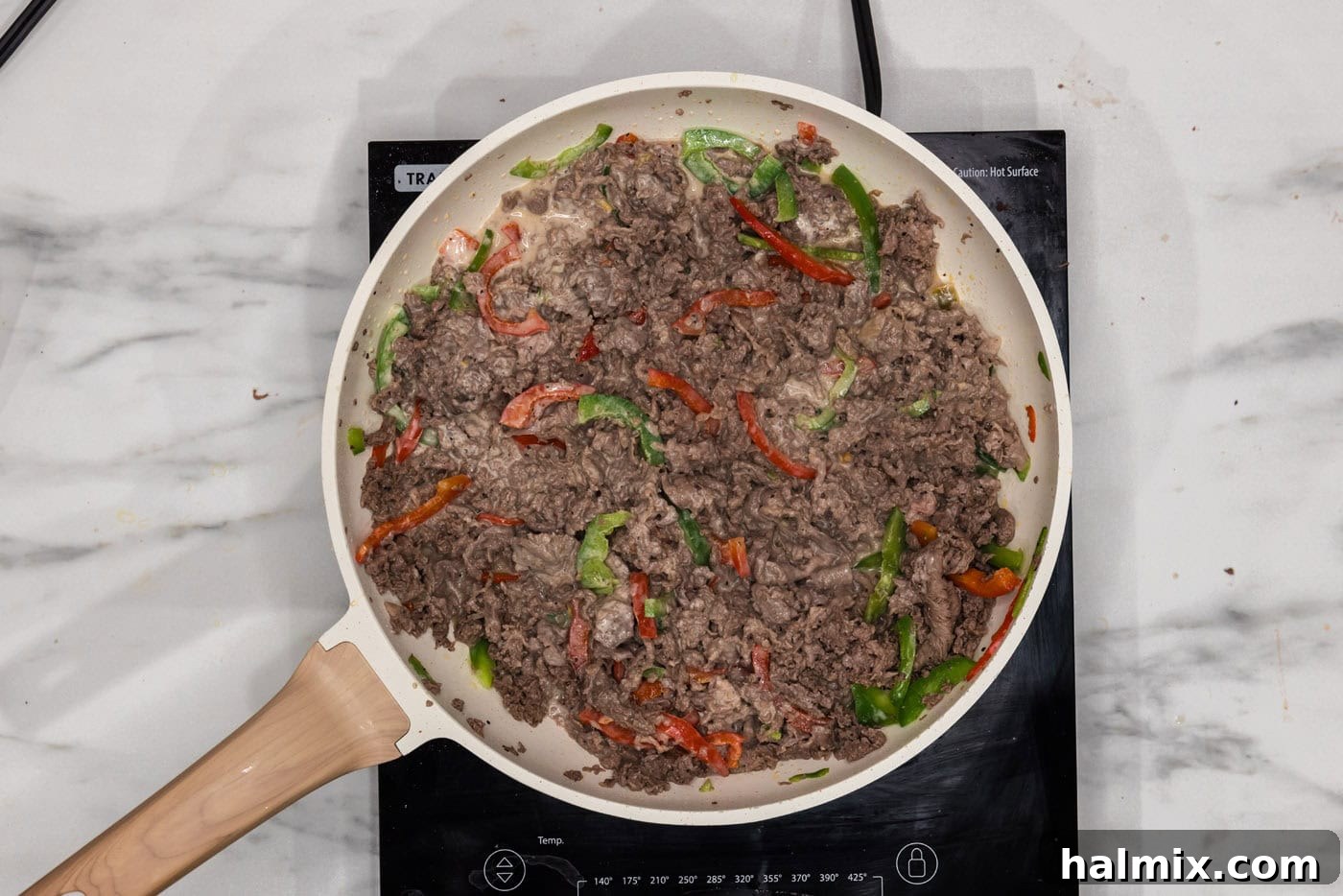 bell peppers, beef, and queso in a skillet