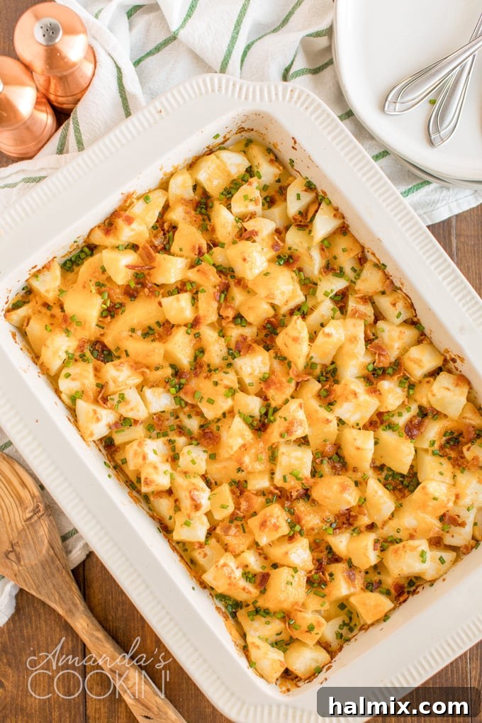 A golden pan of bubbling three-cheese potatoes, garnished with crisp bacon and fresh chives, ready to serve a crowd.