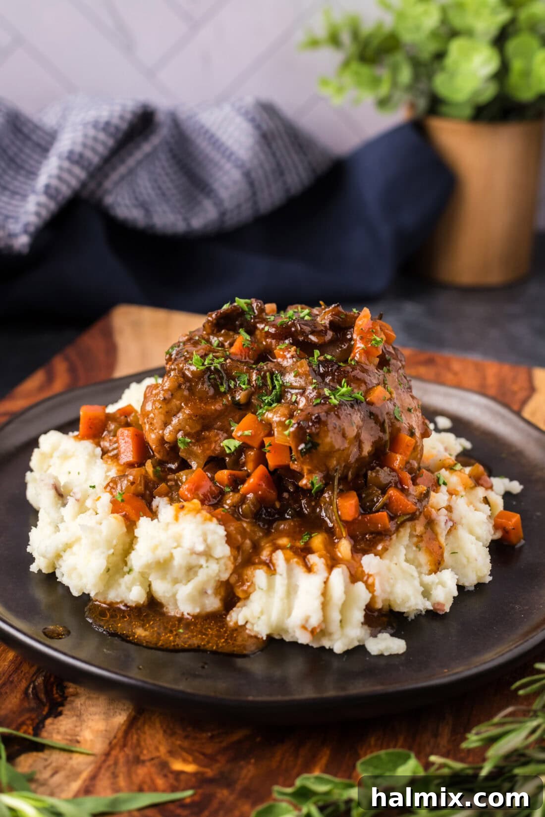 Fork-Tender Oxtail 3 Braised Oxtail served over mashed potatoes on a plate