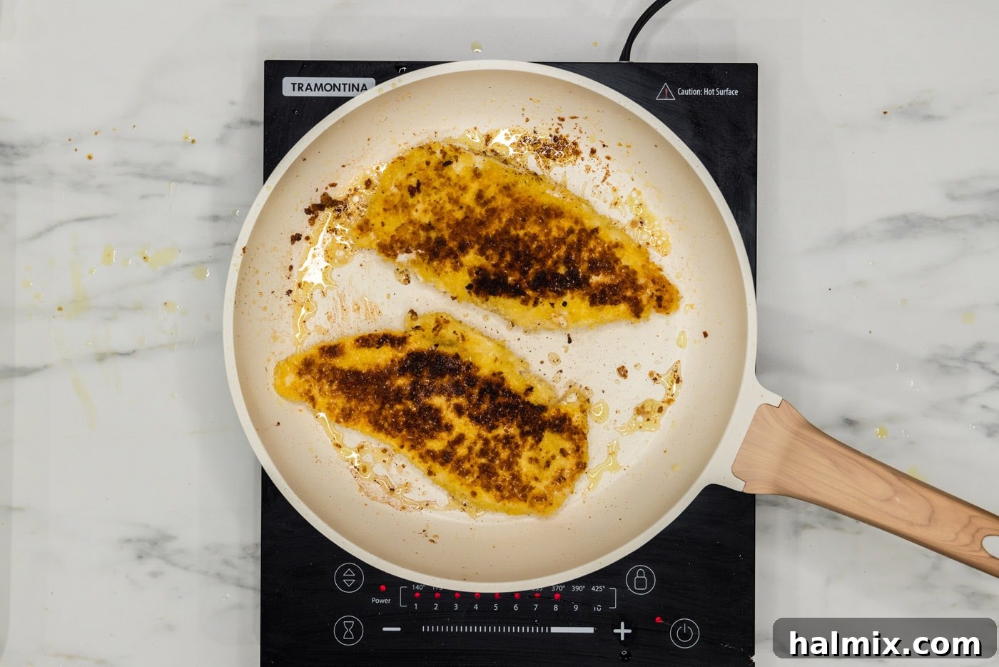 Perfectly pan-fried chicken cutlets on a plate, golden and crispy.