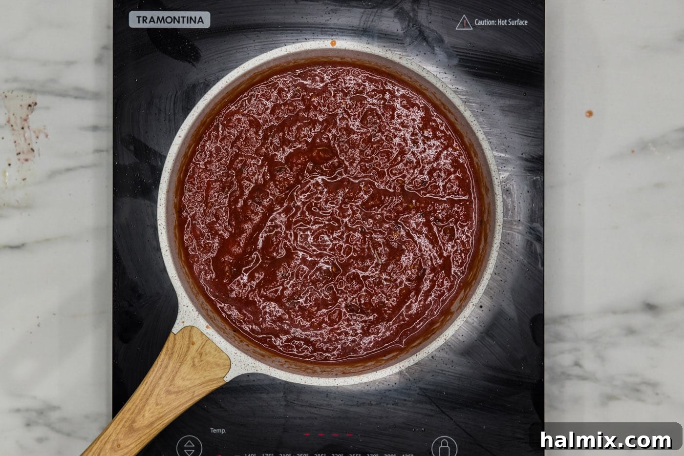 Homemade marinara sauce simmering gently in a skillet.