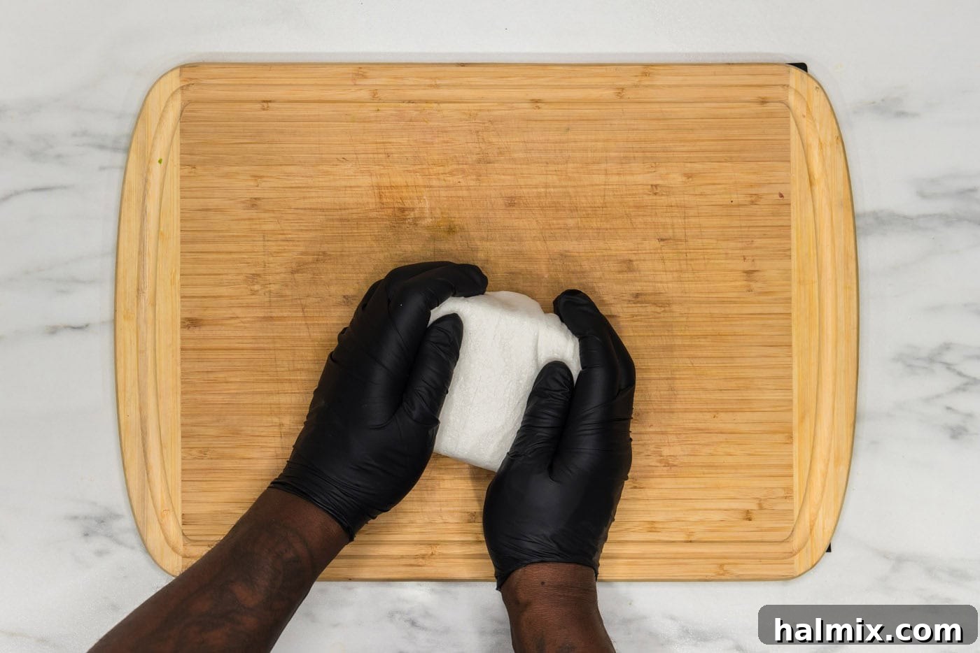 Unbelievably Crispy Air Fryer Tofu 5 squeezing excess moisture out of tofu block