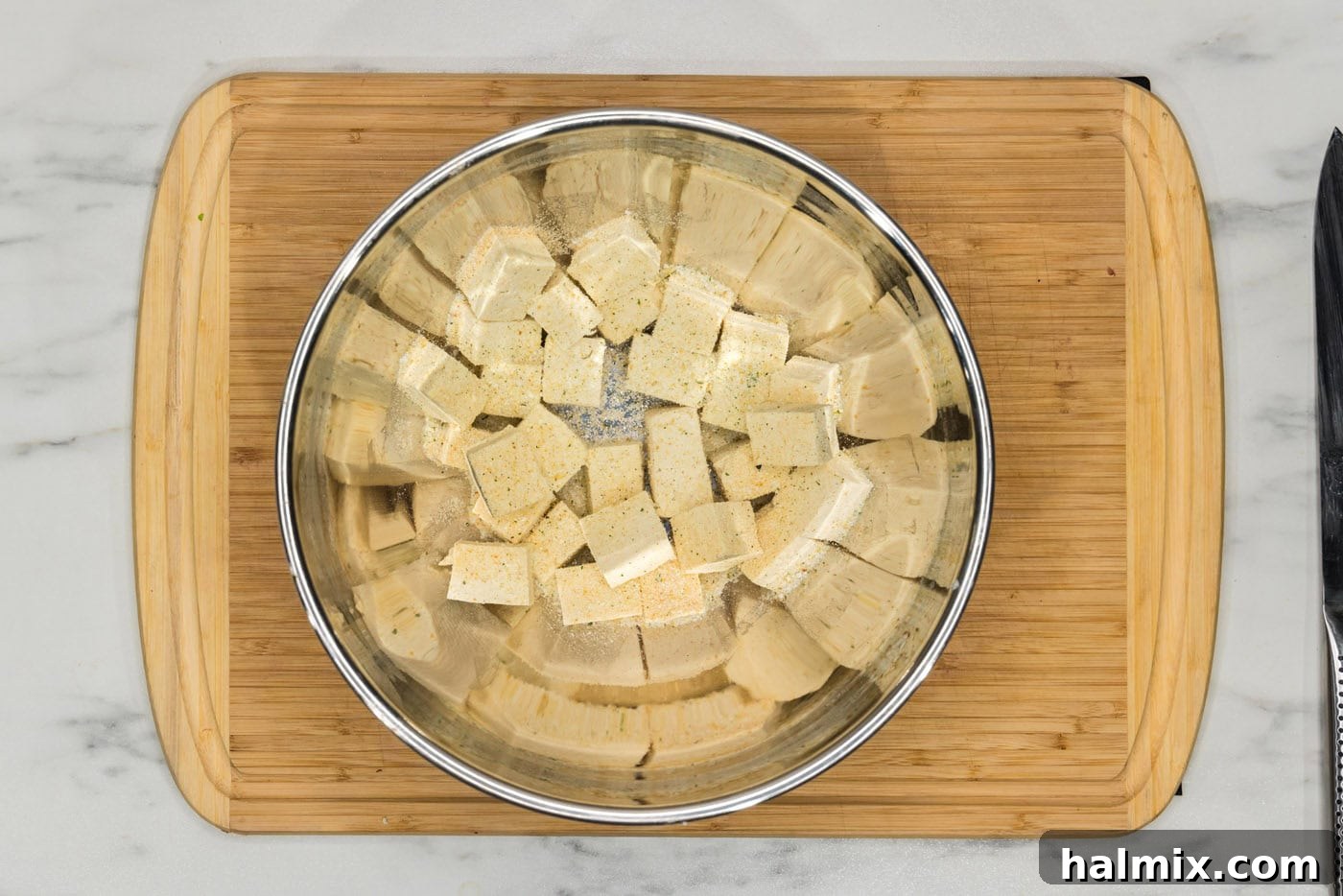 Unbelievably Crispy Air Fryer Tofu 6 cubed tofu in a bowl with seasonings