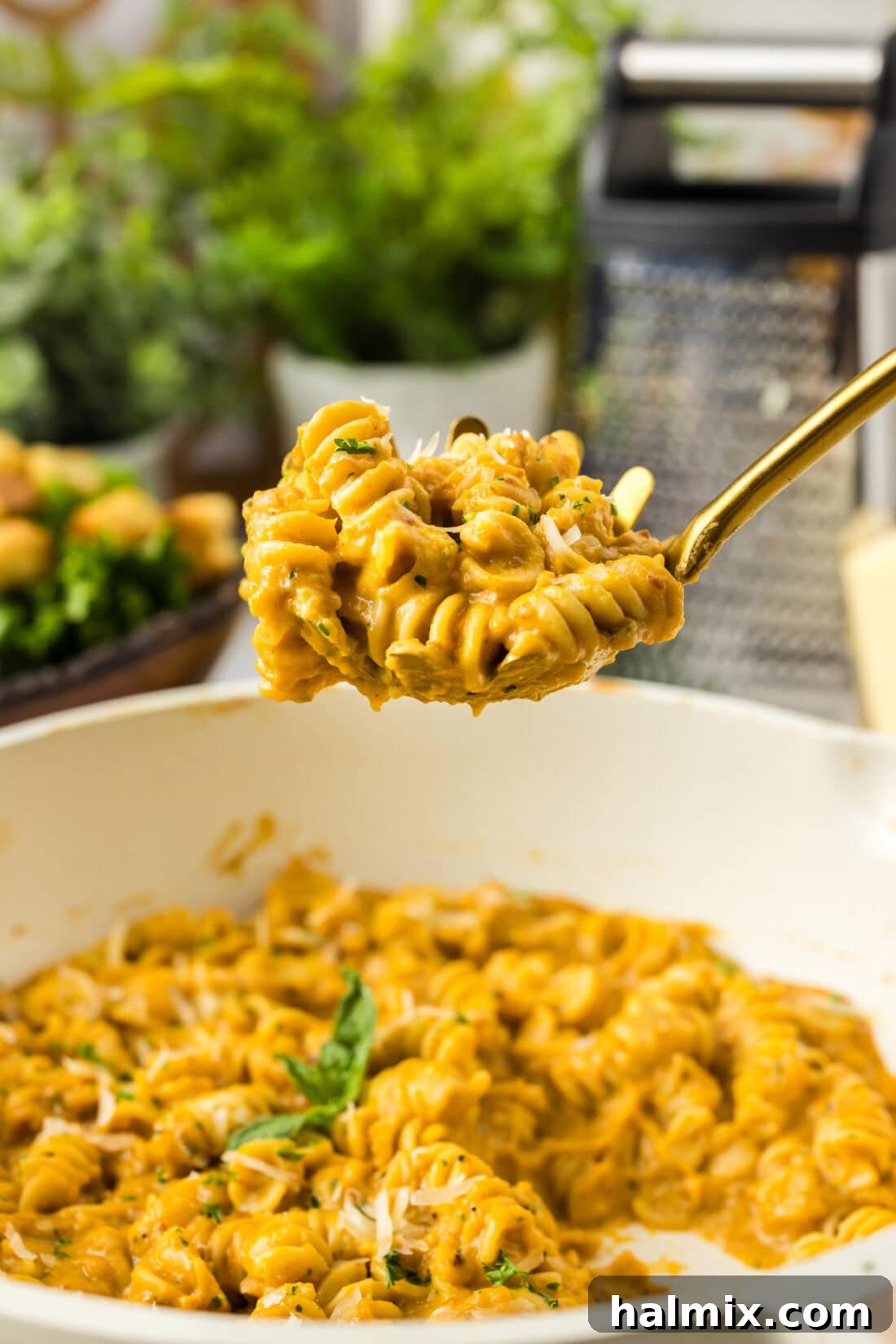 Velvety Butternut Squash Pasta 3 Serving spoon full of Butternut Squash Pasta held above a skillet