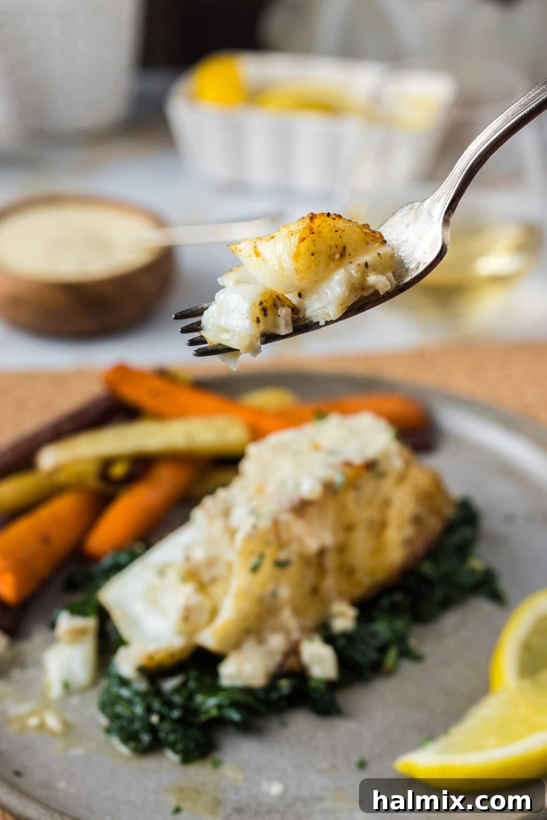 A perfectly cooked piece of Baked Chilean Sea Bass on a fork