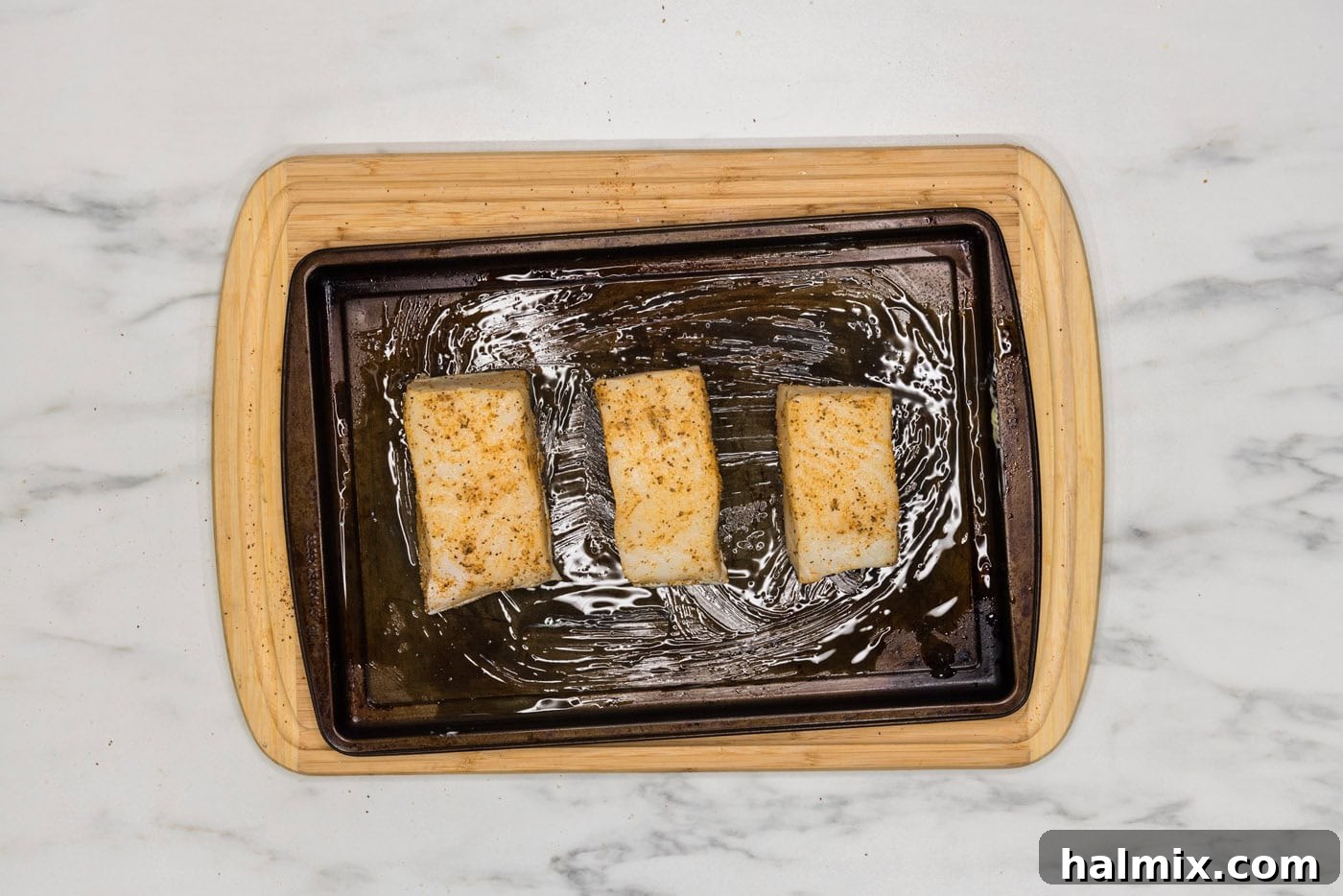 chilean sea bass filets on a baking sheet, ready for baking