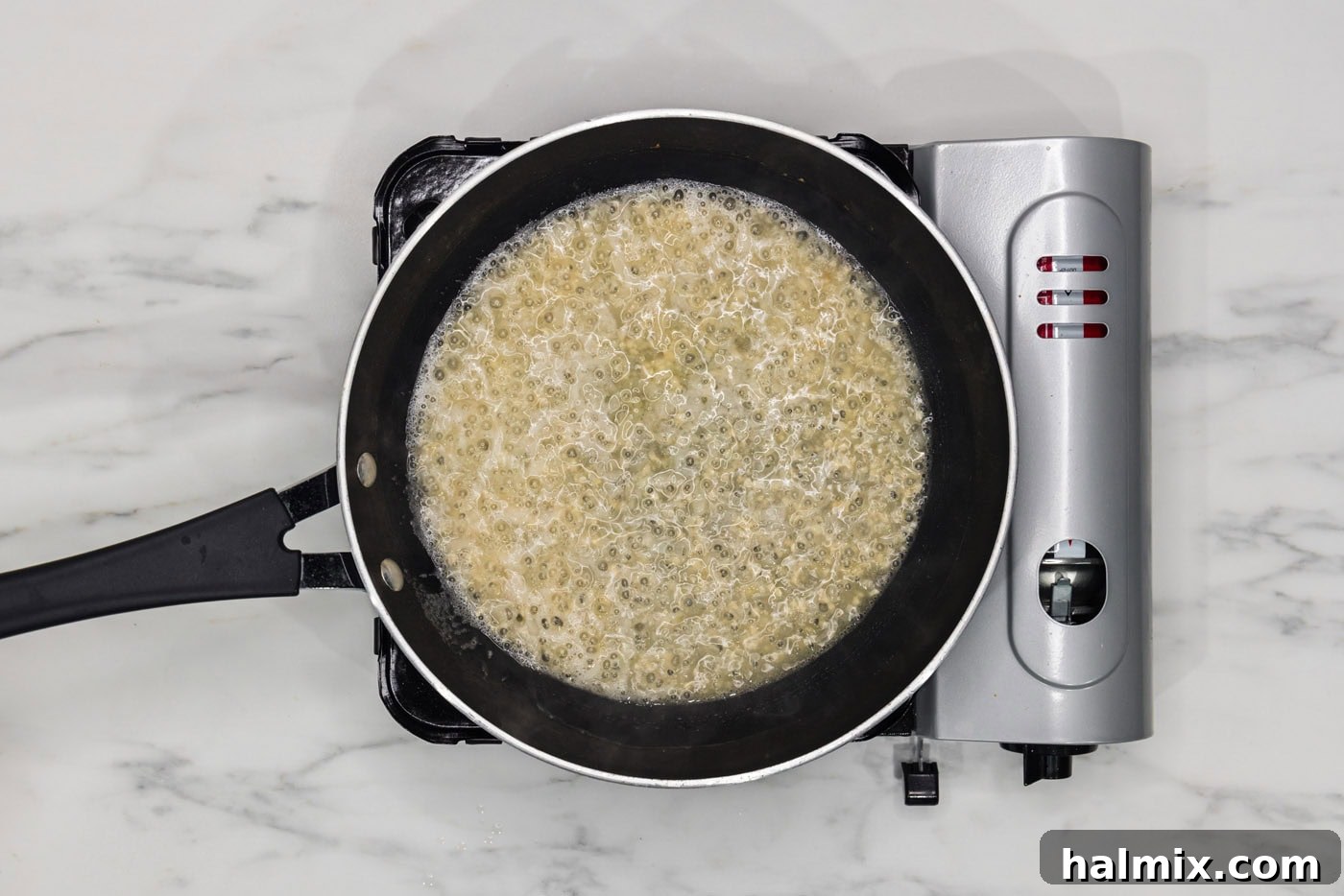 shallots and garlic cooking in butter in a skillet with white wine reducing
