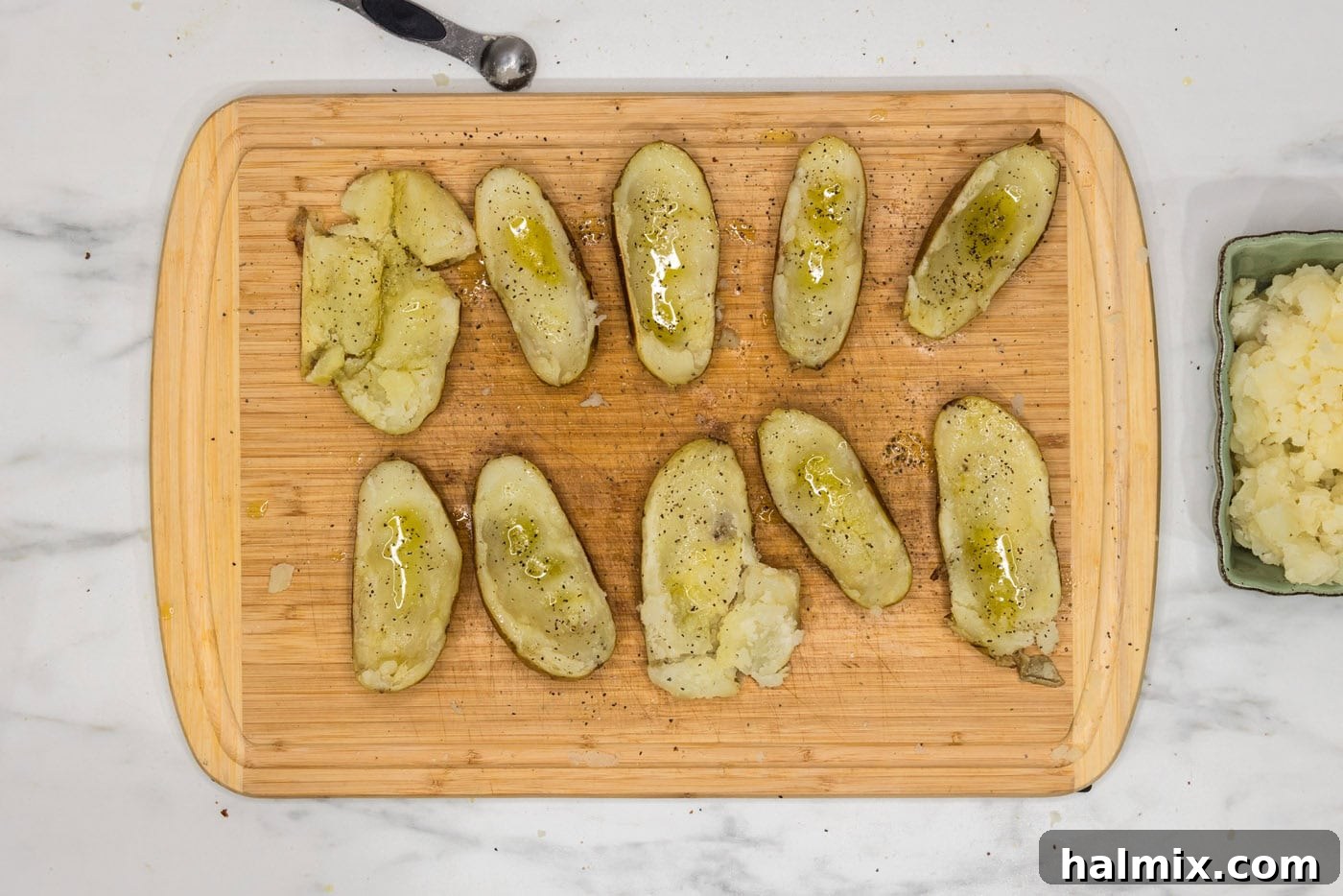 Loaded Potato Skins 8 potato skins on a cutting board seasoned with salt and pepper