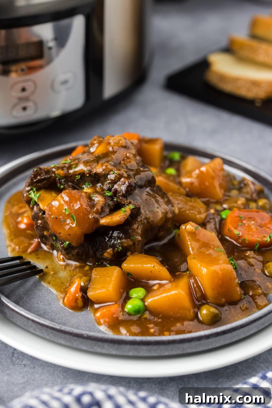 Melt-in-Your-Mouth Slow Cooker Oxtail 12 Close up photo of a portion of Slow Cooker Oxtail on a plate, showing the tender meat and rich gravy.