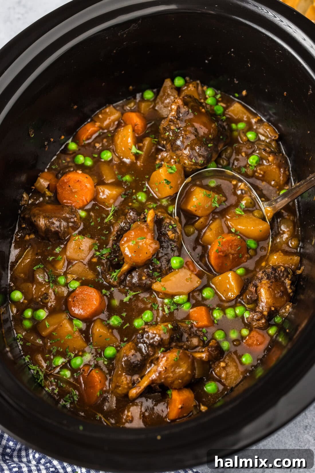 Melt-in-Your-Mouth Slow Cooker Oxtail 3 Close up photo of Slow Cooker Oxtail in a crockpot, showing the rich gravy and vegetables.
