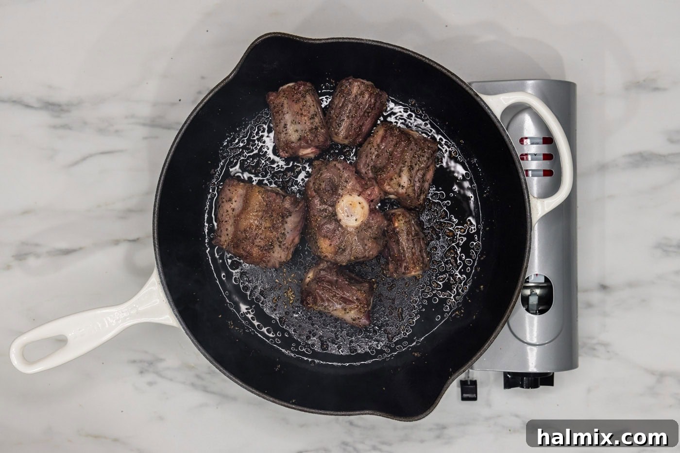 Melt-in-Your-Mouth Slow Cooker Oxtail 5 Browned oxtail pieces in a skillet after searing.