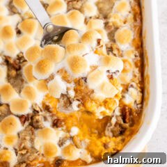 Close up photo of a spoonful of Sweet Potato Casserole in the casserole dish