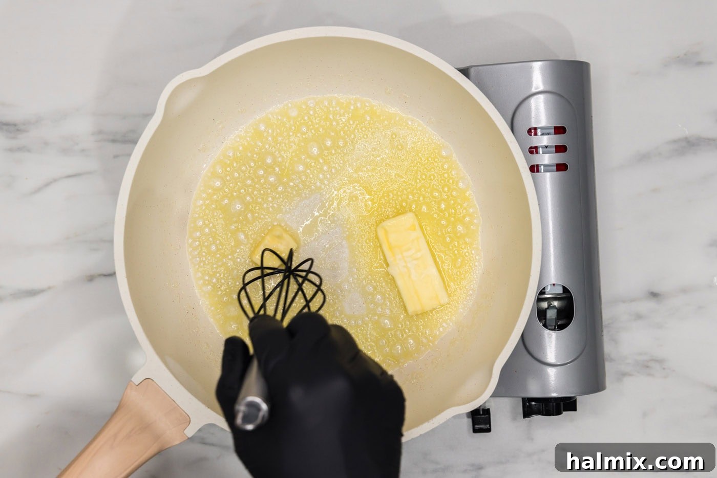 whisking butter in a skillet over heat