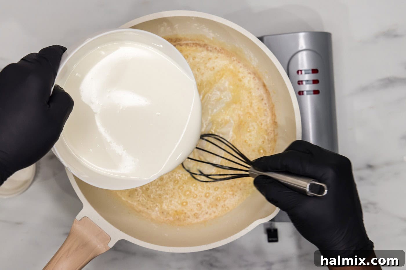 pouring half and half into a skillet with butter and flour mixture