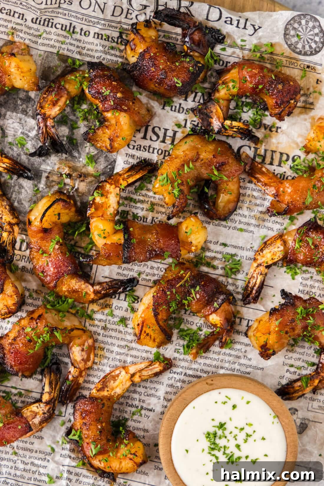 Close up photo of Air Fryer Bacon Wrapped Shrimp on parchment paper with a golden glaze