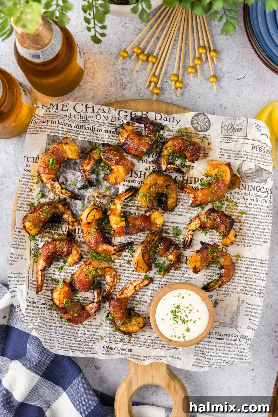 Air Fryer Bacon Wrapped Shrimp arranged on a parchment lined board, garnished and ready to serve