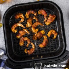 Air Fryer Bacon Wrapped Shrimp in an air fryer basket, ready to be served