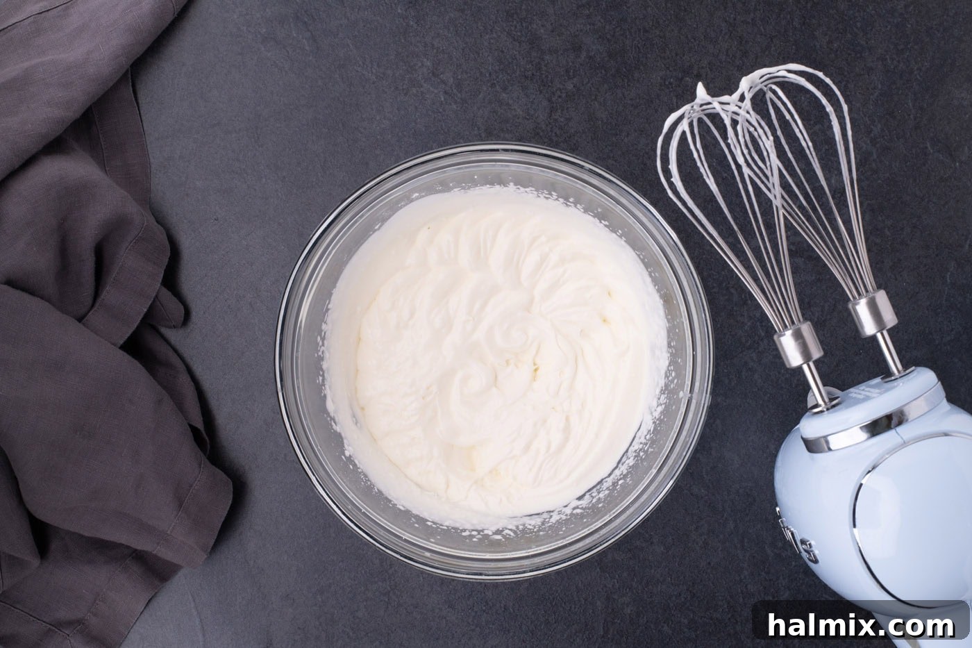 Spooky Sweet Candy Corn Cheesecake Minis 12 Fluffy whipped cream in a bowl next to a hand mixer, ready for piping.
